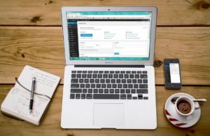 a laptop with a coffee on the side